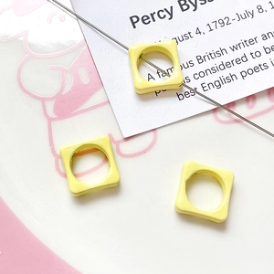 Macro shot of yellow square enamel flower beads for DIY jewelry making and handmade crafts