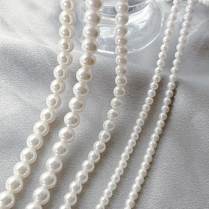White shell pearl accessories in multiple sizes with glossy finish on silk fabric