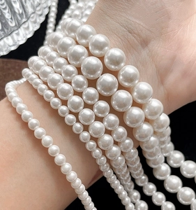 Macro shot of assorted size white pearl beads showing high luster for DIY jewelry making