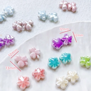 Macro view of 12mm and 13mm clover ceramic beads with pearl glaze for DIY jewelry