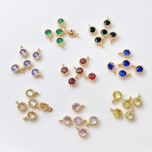 Detalle de colgantes redondos de circón chapados en oro 18k con bordes milgrain en 8 colores