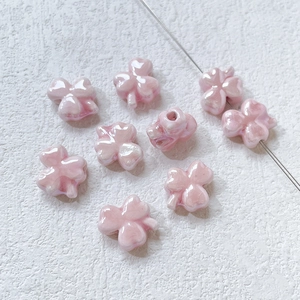 Macro detail of pink pearlescent clover ceramic beads for DIY handmade jewelry crafts