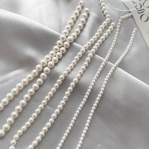 Various sizes of high-luster shell pearls on silver satin for DIY jewelry making