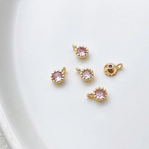 Detalle de cinco dijes de circón rosa bañados en oro 18k para creación de joyería
