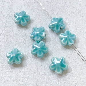 Macro view of blue ceramic clover beads with threading hole for DIY jewelry making