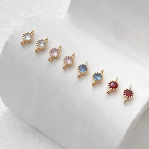 Dettaglio macro di connettori in zircone colorato placcati oro 14k per creazione gioielli