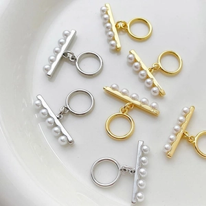 Close-up of gold and silver plated OT toggle clasps with pearls for DIY jewelry making