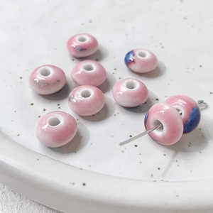 Macro detail of handmade floral ceramic beads with pink and blue glaze for DIY jewelry