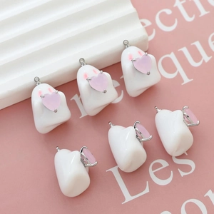 Detailed view of six cute white acrylic ghost charms with pink hearts for DIY jewelry