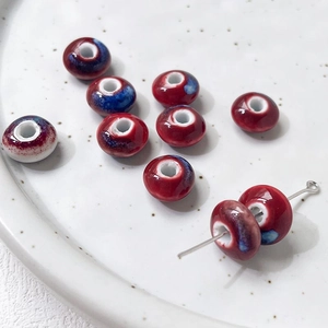 Macro detail of deep red ceramic beads with blue glaze for DIY jewelry making