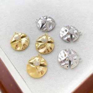 Detailansicht von 14k Gold- und Silberherzanhängern mit Zirkonia-Inlay auf einem Tablett