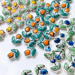 Macro detail of hand-painted tulip ceramic beads for DIY jewelry making accessories