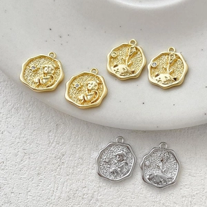 Detailed view of 14k gold-plated Little Prince coin charms with hammered texture finish