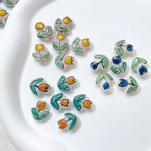 Macro view of handmade ceramic tulip flower beads with hand-painted glaze for DIY jewelry