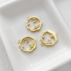 Detailed view of 14k gold-plated celestial pendant with white zircons on ceramic tray