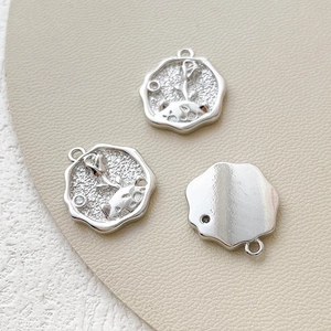 Macro shot of silver plated relief charms showing Little Prince and rose patterns