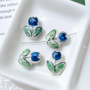 Macro detail of hand-painted blue tulip ceramic beads for DIY jewelry and crafts
