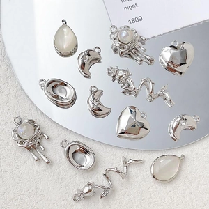 Detailed view of silver DIY pendants with crescent moon, heart, and rose charm accents