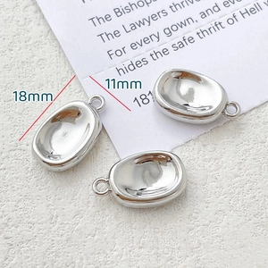 Detailed view of silver oval bean pendants with 18mm length and smooth mirror finish