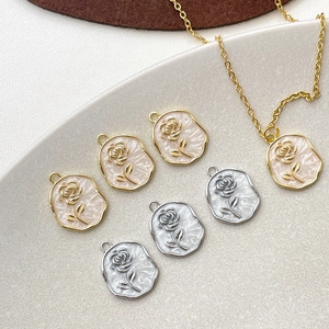 Detailed view of 14k gold-plated rose relief charms and finished pendant necklace