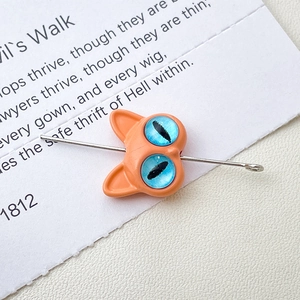 Macro shot of orange monster cat bead with blue opal eyes for custom jewelry making