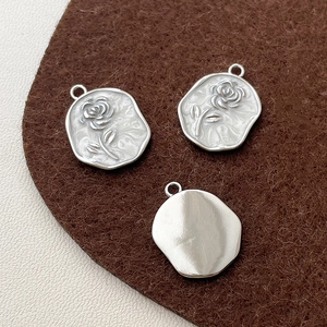 Macro view of 14k gold-filled rose embossed round charms for DIY jewelry making