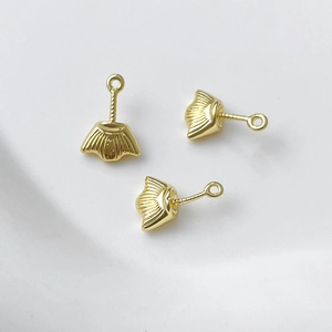 Macro di tre ciondoli a conchiglia placcati oro con linee radiali per creazione gioielli