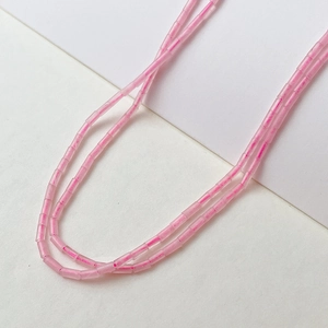 Makroansicht der 2x4 mm rosafarbenen matten Kristall-Röhrenperlen für DIY-Schmuckherstellung