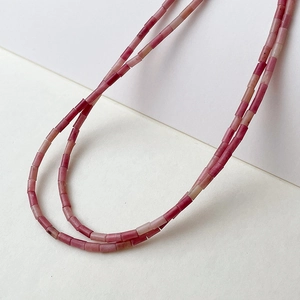 Makroaufnahme von Natur-Rosenquarz-Röhrenperlen in eleganten rosa-roten Farbverläufen