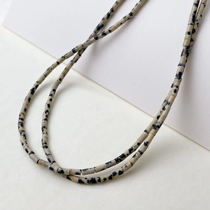 Makroaufnahme von 2x4mm Dalmatiner-Jaspis-Röhrenperlen für DIY-Schmuckmaterial