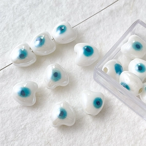Vista macro de cuentas de cerámica con corazón de mal de ojo para manualidades de joyería DIY