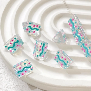 Macro view of hand-painted acrylic beads with blue stripes and colorful dots for DIY