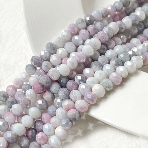 Dettaglio di perline sfaccettate da 8mm nei toni lavanda e rosa su un piatto in ceramica