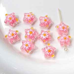 Macro detail of pink glass star beads with floral patterns for DIY jewelry making