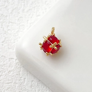 Macro di un ciondolo a forma di coccinella placcato oro 14k con gemma rossa e punti dorati