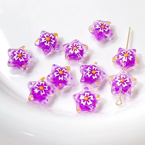 Detail showing purple glass star beads with white floral pattern for DIY jewelry making