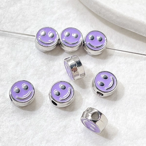 Macro detail of purple enamel smiley face beads for DIY bracelet and jewelry making