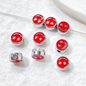 Detailed shot of red enamel smiley face beads for DIY bracelet and necklace jewelry making