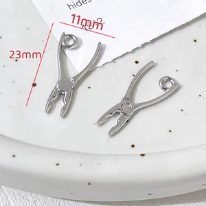 Détail d'un pendentif mini clé à molette argenté de 23x11mm pour la création de bijoux