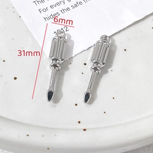 Vue macro de pendentifs tournevis argentés pour bijoux DIY avec marquages de taille