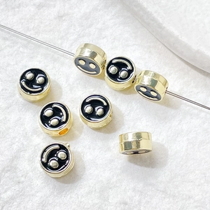Macro detail of gold plated smiley face beads for DIY jewelry making and bracelets