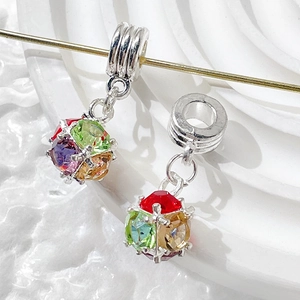 Macro shot of silver sphere pendants with colorful zircons on a golden metal rod