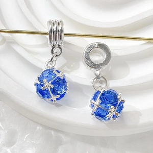 Macro shot of two deep blue faceted crystal sphere charms with silver metal bails on display