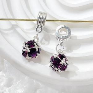 Close-up of purple zircon crystal beads in silver cage charms for DIY jewelry making