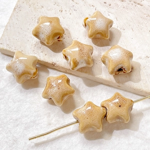 Detail of star-shaped ceramic beads in yellow crackle glaze for DIY jewelry making
