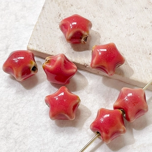 Detailed macro shot of red star ceramic beads with reactive glaze for DIY jewelry