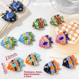 Dettaglio macro di perline di pesce in ceramica dipinte a mano per gioielli DIY