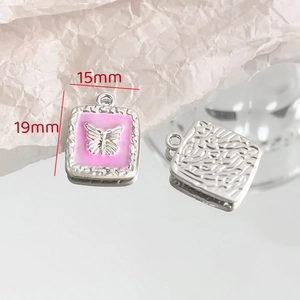 Detailed macro view of 15x19mm square alloy butterfly pendant with pink enamel detail