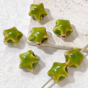 Macro shot of green star shaped ceramic beads with kiln glaze texture for DIY jewelry