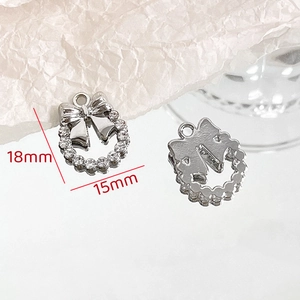 Detail view of a sparkling silver bow wreath pendant with rhinestones, 18mm by 15mm size